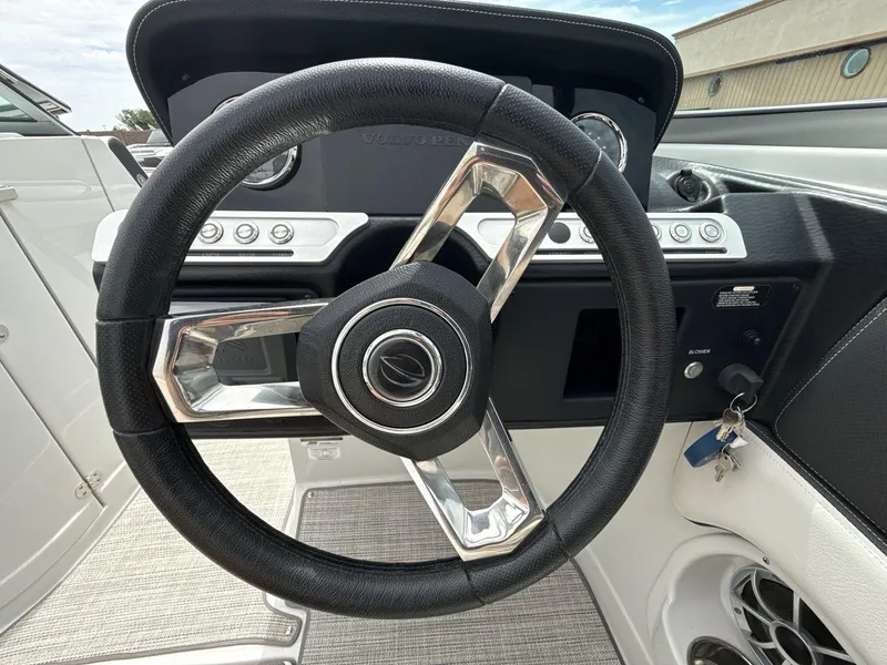 Slide: The Image of Steering wheel of 2022 Crownline Eclipse E235 SURF boat, featuring modern dashboard controls. - 14