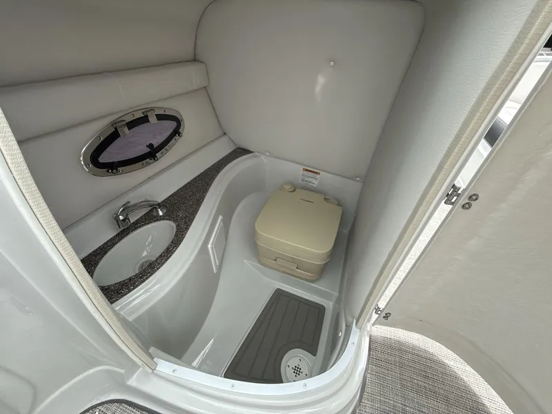 Slide: The Image of 2022 Crownline Eclipse E235 SURF boat interior bathroom with sink and portable toilet. - 18