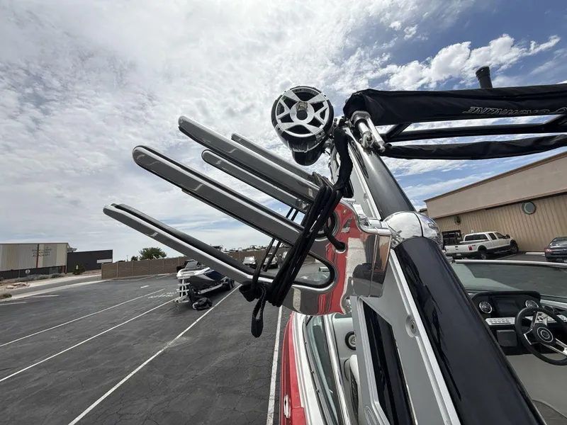 Slide: The Image of 2022 Crownline Eclipse E235 SURF boat with wakeboard rack and speaker, parked outdoors. - 22