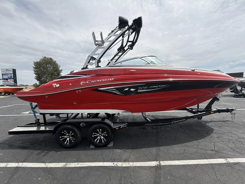 Slide: The Image of 2022 Crownline Eclipse E235 SURF boat in vibrant red on a trailer. - 6