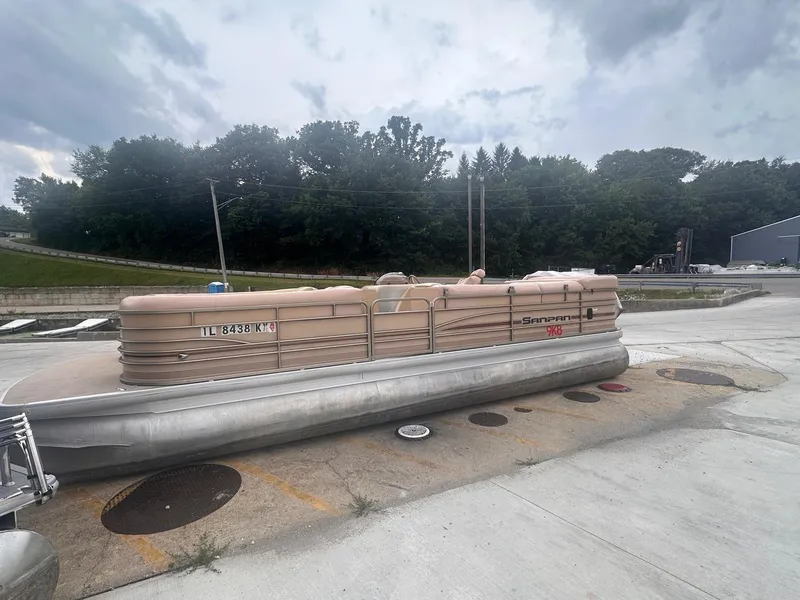 Slide: The Image of 2008 Godfrey Sanpan 2500 RE pontoon boat on concrete surface, cloudy sky background. - 2