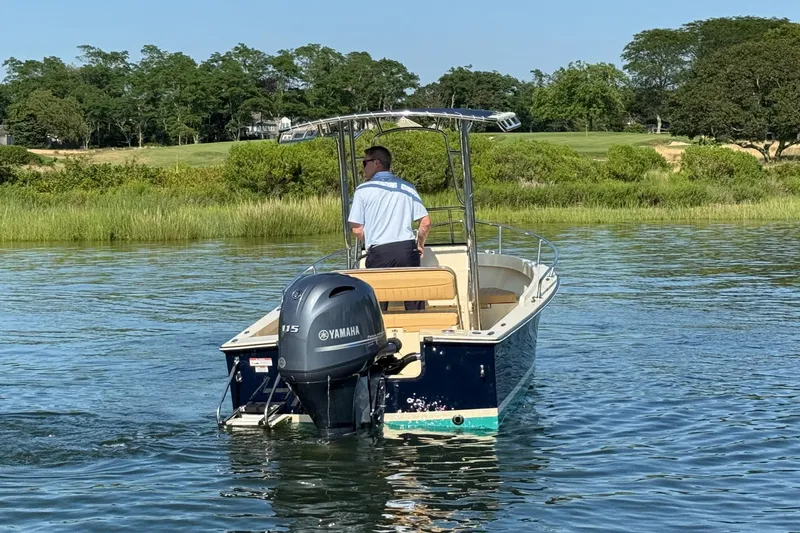 Slide: The Image of Man steering a 2026 Rossiter 17 boat with Yamaha engine on a calm river. - 10