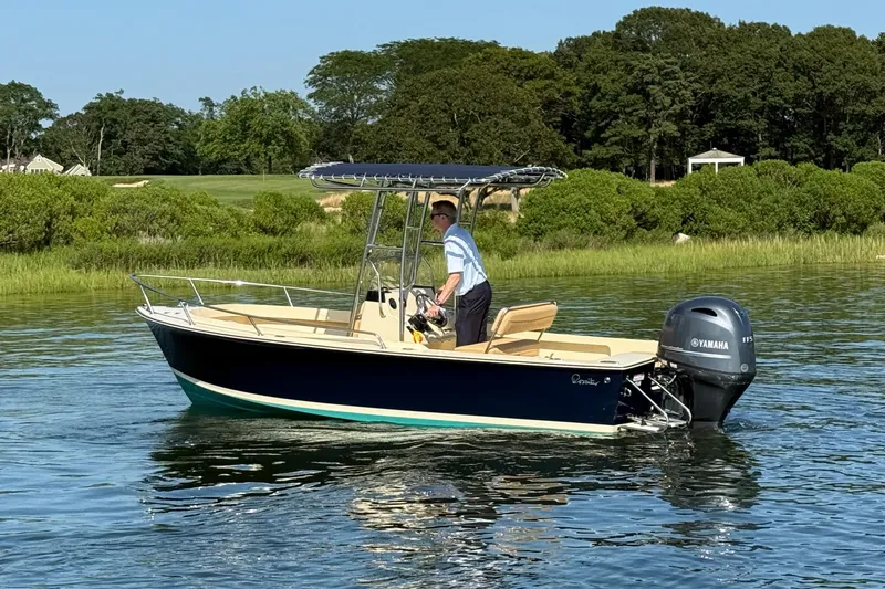 Slide: The Image of 2026 Rossiter 17 boat with Yamaha engine on calm water, surrounded by lush greenery. - 14