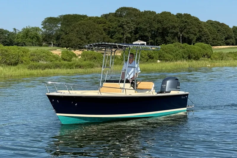 Slide: The Image of 2026 Rossiter 17 boat cruising on a calm lake with lush greenery in the background. - 2