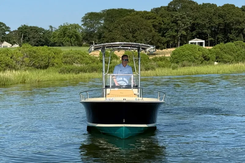Slide: The Image of 2026 Rossiter 17 boat on calm water with lush green shoreline in the background. - 4