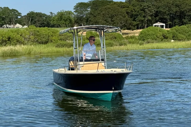 Slide: The Image of A 2026 Rossiter 17 boat cruising on a serene lake with lush greenery. - 5