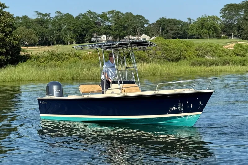 Slide: The Image of 2026 Rossiter 17 boat on calm water, surrounded by lush greenery. - 7