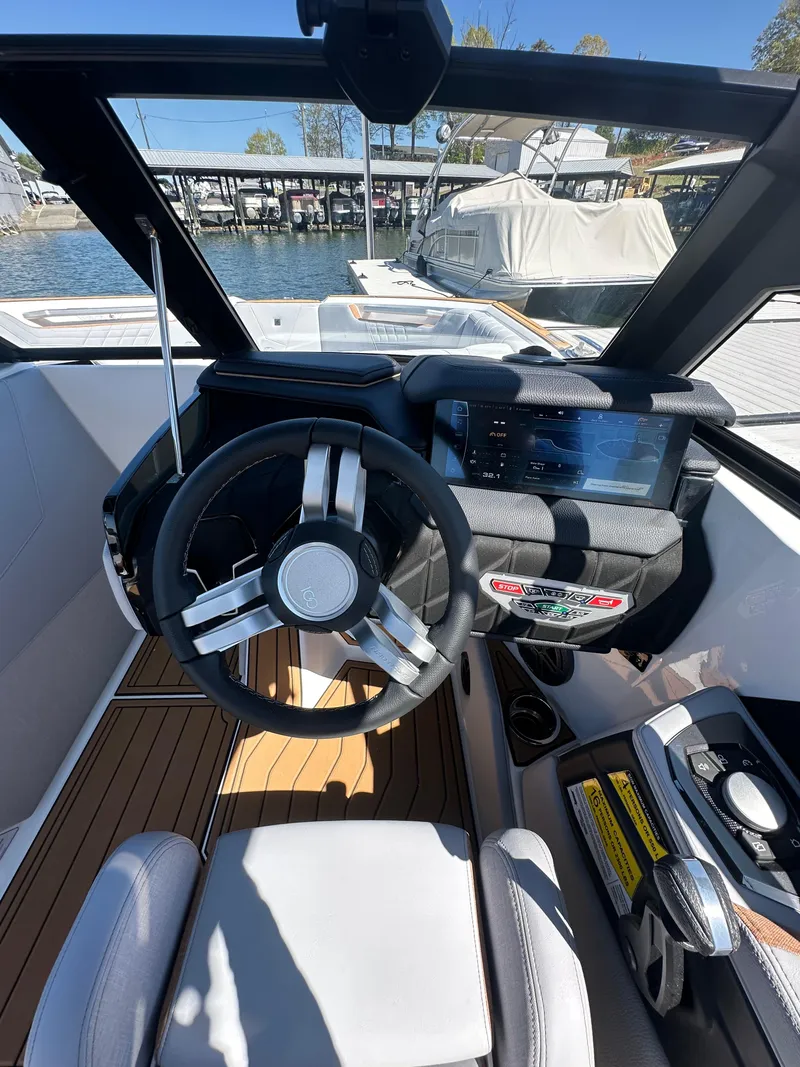 Slide: The Image of 2025 Nautique Super Air Nautique S23 boat cockpit with steering wheel and digital display. - 15