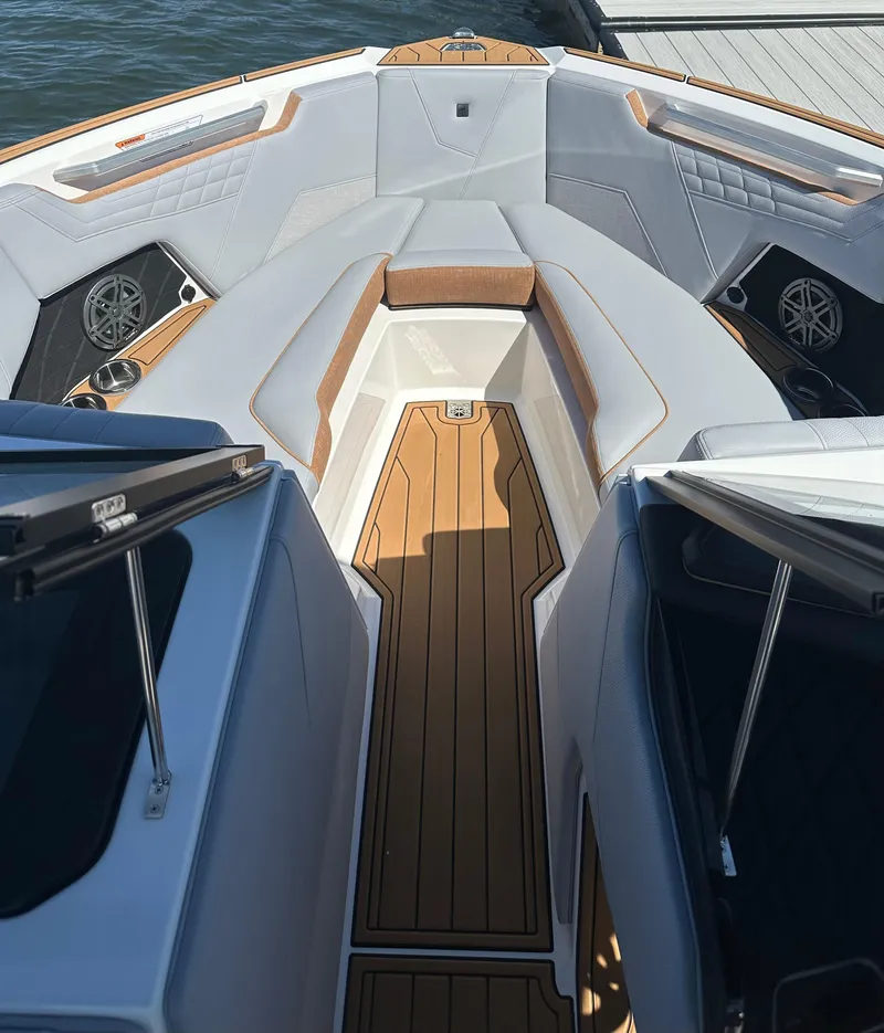Slide: The Image of 2025 Nautique Super Air Nautique S23 boat interior with sleek seating and wood accents. - 18
