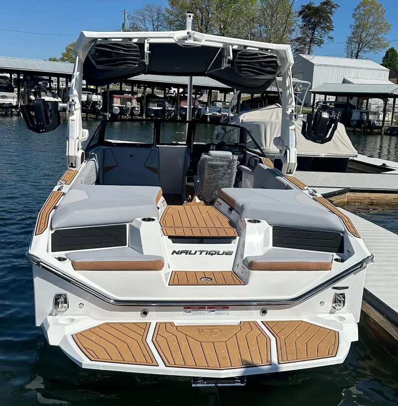 Slide: The Image of 2025 Nautique Super Air Nautique S23 boat docked, showcasing sleek design and spacious interior. - 6