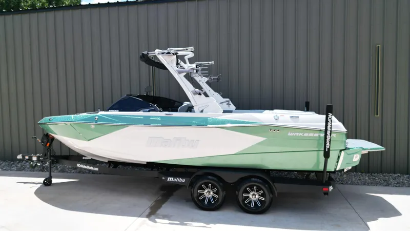 Slide: The Image of 2025 Malibu Wakesetter 23 LSV boat on trailer, green and white design. - 3