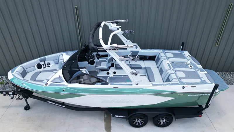 Slide: The Image of 2025 Malibu Wakesetter 23 LSV boat, green and white, on trailer, side view. - 6