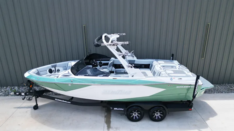 Slide: The Image of 2025 Malibu Wakesetter 23 LSV boat on trailer, green and white design. - 9