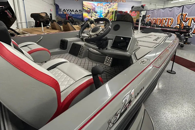 Slide: The Image of 2025 Caymas XS 21 Pro boat interior with red and gray seating, steering wheel, and dashboard. - 4