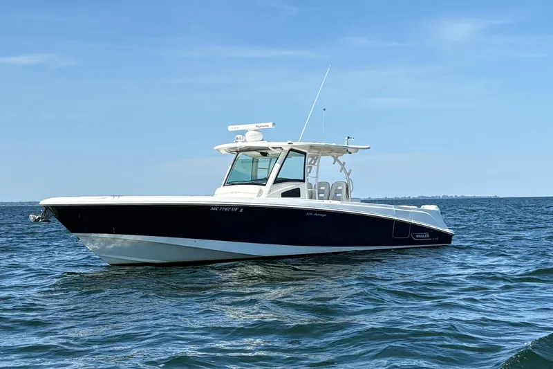 The Image of 2014 Boston Whaler 370 Outrage boat on open water under clear blue sky. - 0