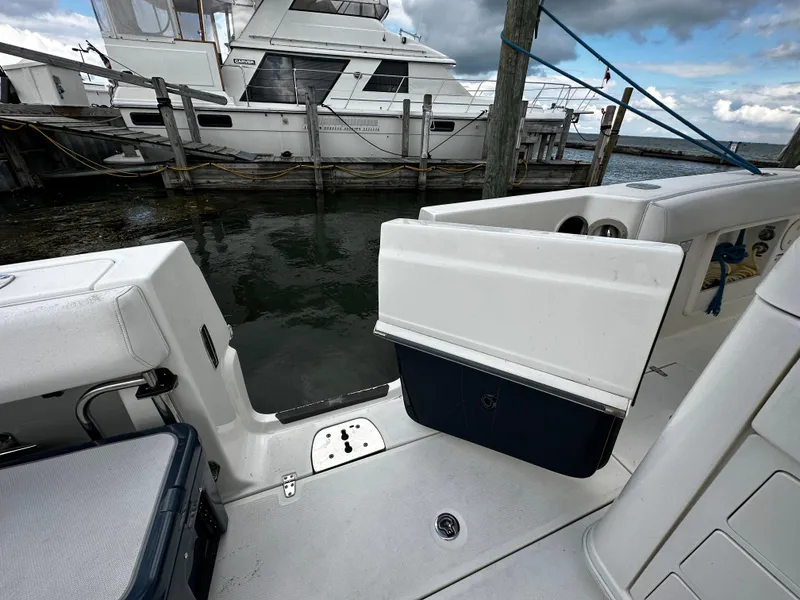 Slide: The Image of 2014 Boston Whaler 370 Outrage with triple outboard engines and cushioned seating. - 16