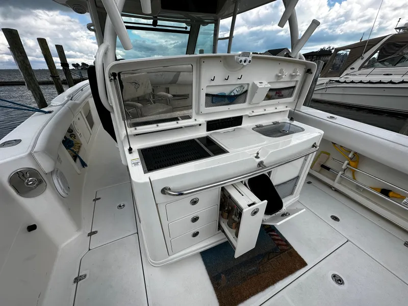 Slide: The Image of 2014 Boston Whaler 370 Outrage boat interior with docked yachts in the background. - 18
