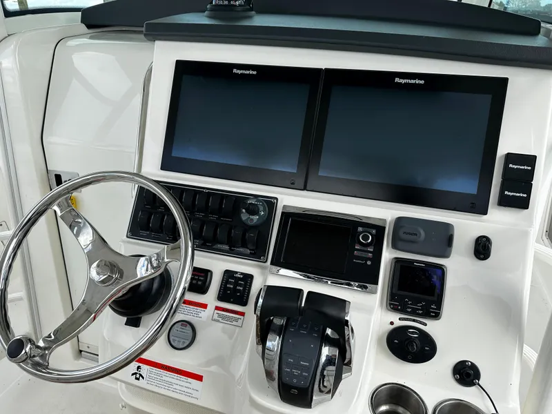 Slide: The Image of 2014 Boston Whaler 370 Outrage boat docked, open side door, and nearby yacht. - 19