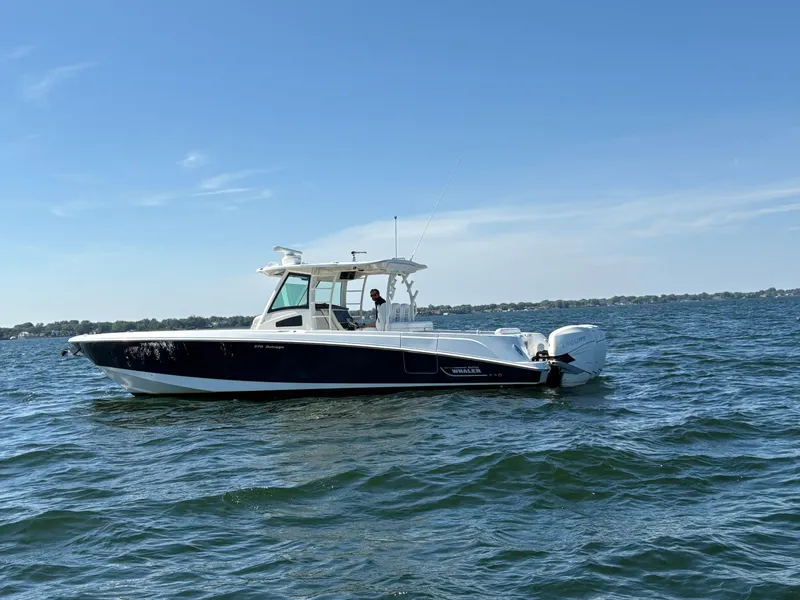 Slide: The Image of 2014 Boston Whaler 370 Outrage boat on open water under clear blue sky. - 2