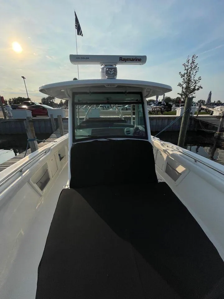 Slide: The Image of 2014 Boston Whaler 370 Outrage boat docked, showcasing side seating and ladder. - 27