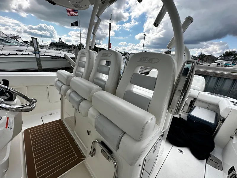 Slide: The Image of 2014 Boston Whaler 370 Outrage boat interior with white seating at marina. - 28
