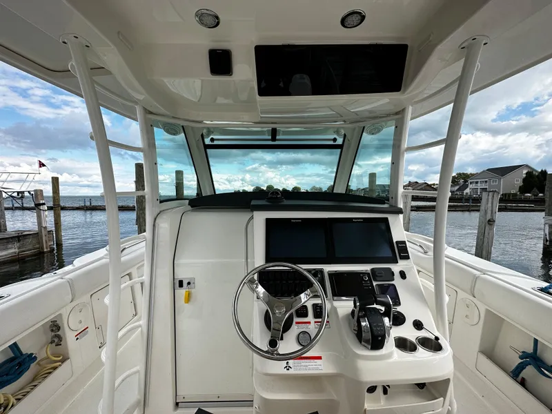 Slide: The Image of 2014 Boston Whaler 370 Outrage helm station with dual screens and steering wheel. - 29