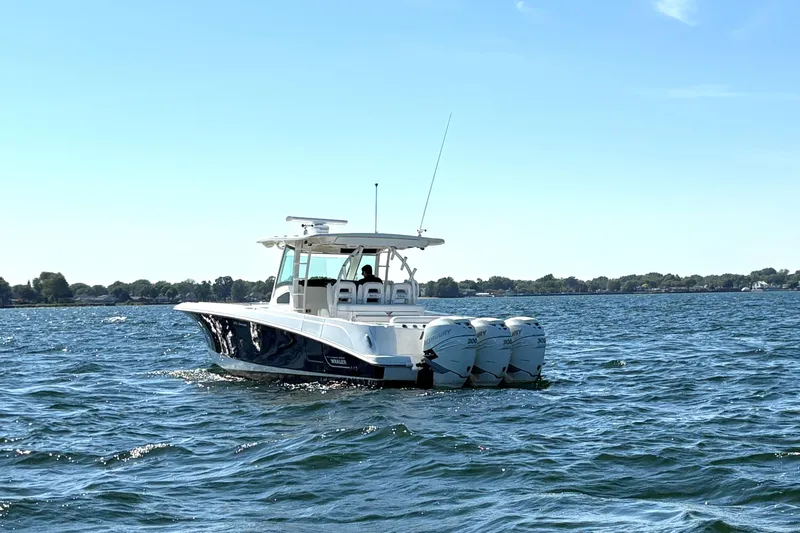 Slide: The Image of 2014 Boston Whaler 370 Outrage boat cruising on open water with triple engines. - 3
