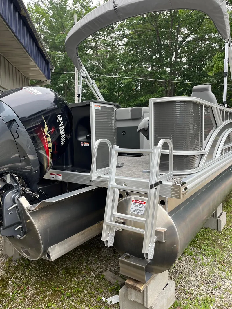 Slide: The Image of 2024 Bennington 22 SS SPS pontoon boat with Yamaha engine and ladder, docked outdoors. - 12