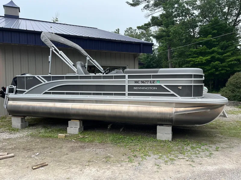 Slide: The Image of 2024 Bennington 22 SS SPS pontoon boat on blocks, parked outdoors. - 14