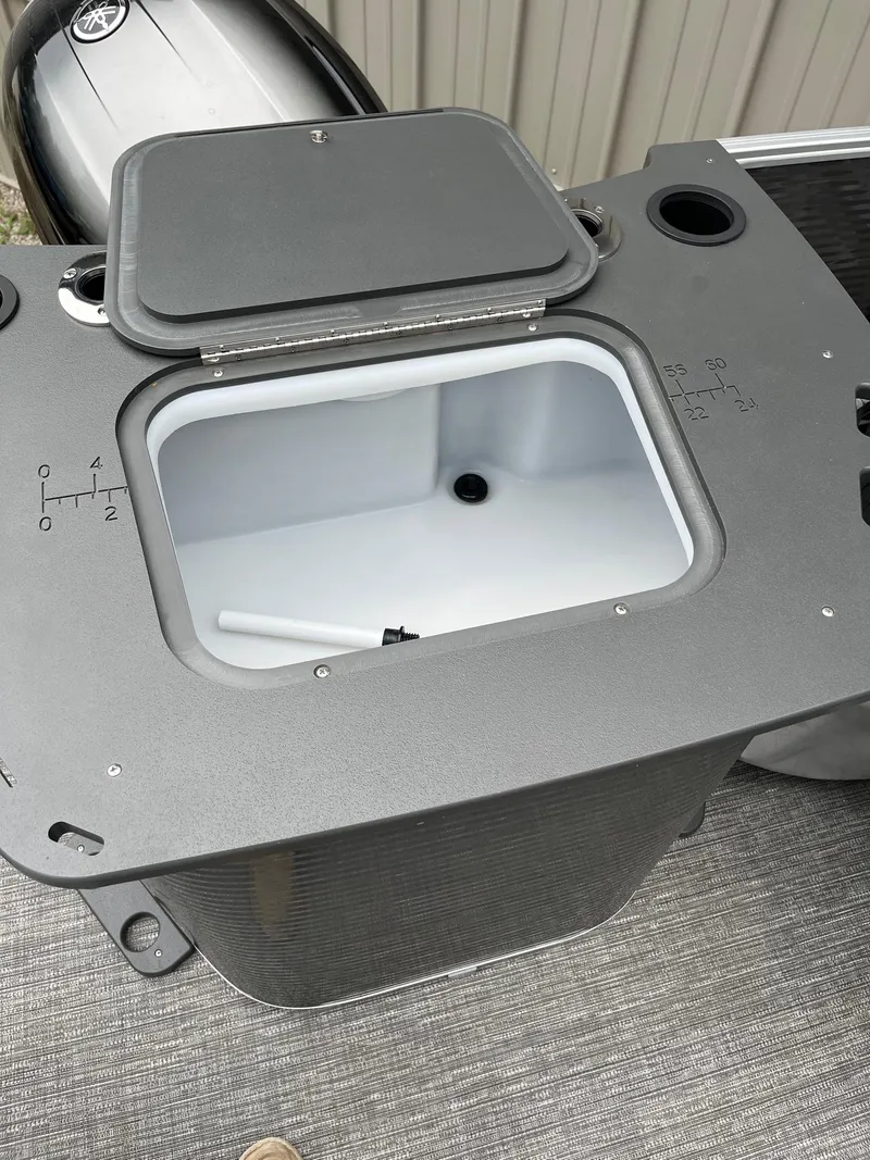 Slide: The Image of Open storage compartment on 2024 Bennington 22 SS SPS boat, featuring a Yamaha engine. - 3