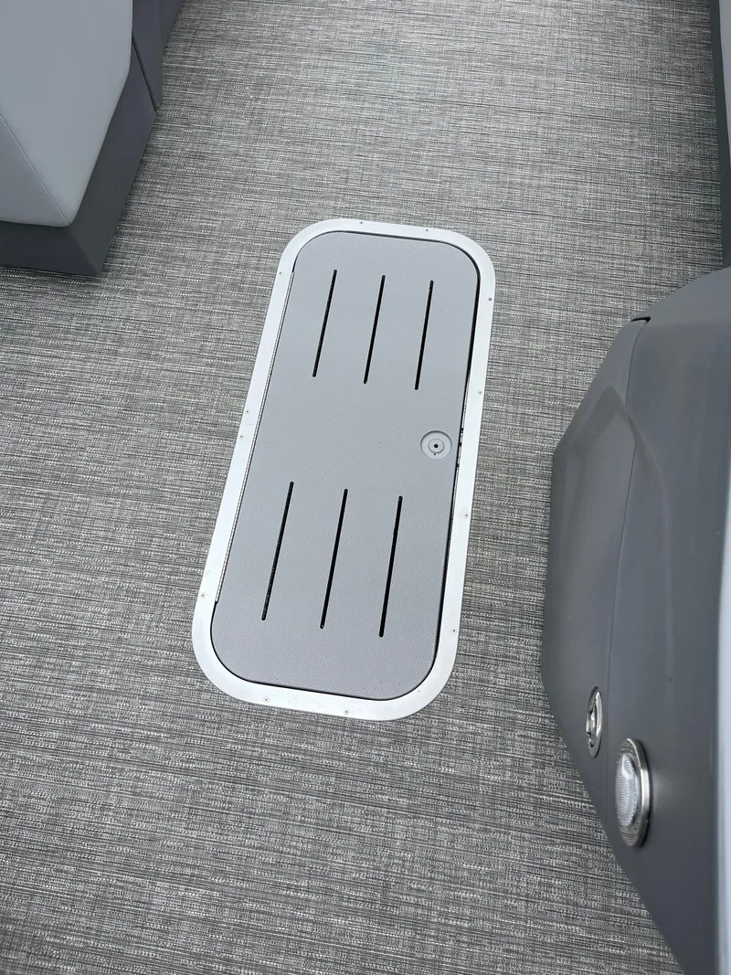 Slide: The Image of 2024 Bennington 22 SS SPS boat floor with storage hatch, featuring sleek gray design. - 8