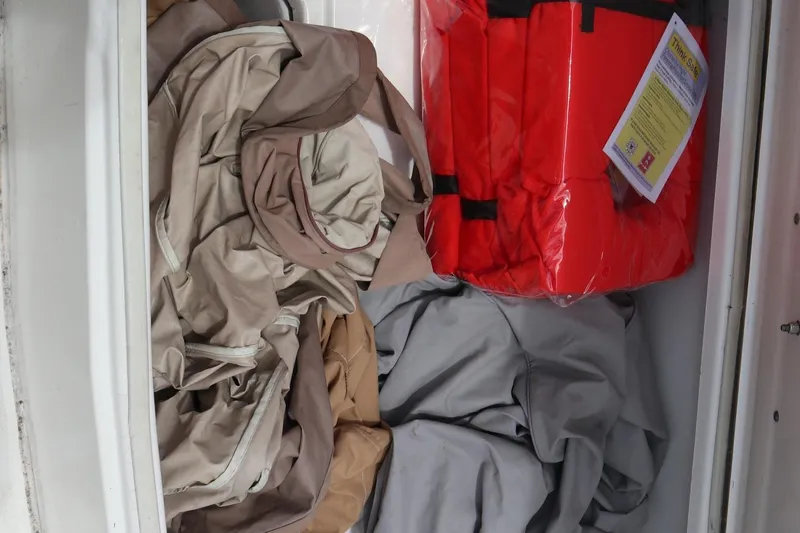 Slide: The Image of Storage compartment in 2016 Sea Fox Commander 288 with life jackets and tarps. - 27