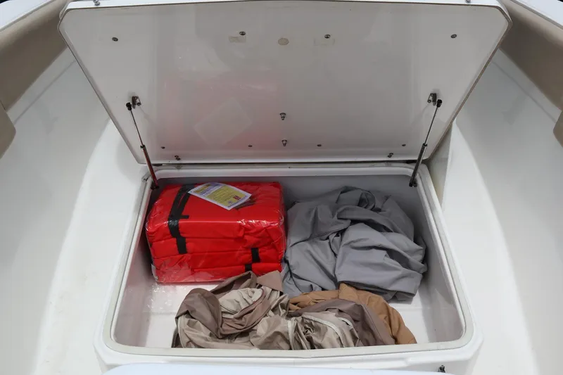 Slide: The Image of Open storage compartment on 2016 Sea Fox Commander 288 boat with life jackets and covers. - 28