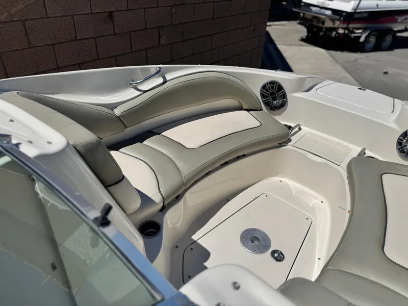 Slide: The Image of 2005 Sea Ray 220 Sundeck interior with cushioned seating and speakers. - 12