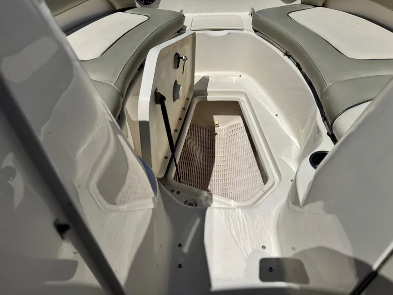 Slide: The Image of 2005 Sea Ray 220 Sundeck interior with open storage compartment and cushioned seating. - 14
