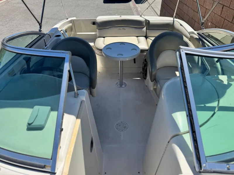 Slide: The Image of 2005 Sea Ray 220 Sundeck interior with seating and table, showcasing spacious design. - 16