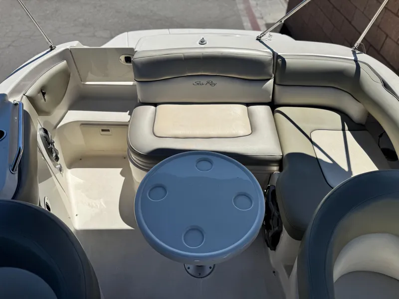 Slide: The Image of 2005 Sea Ray 220 Sundeck interior with seating and table, showcasing luxury boat design. - 17