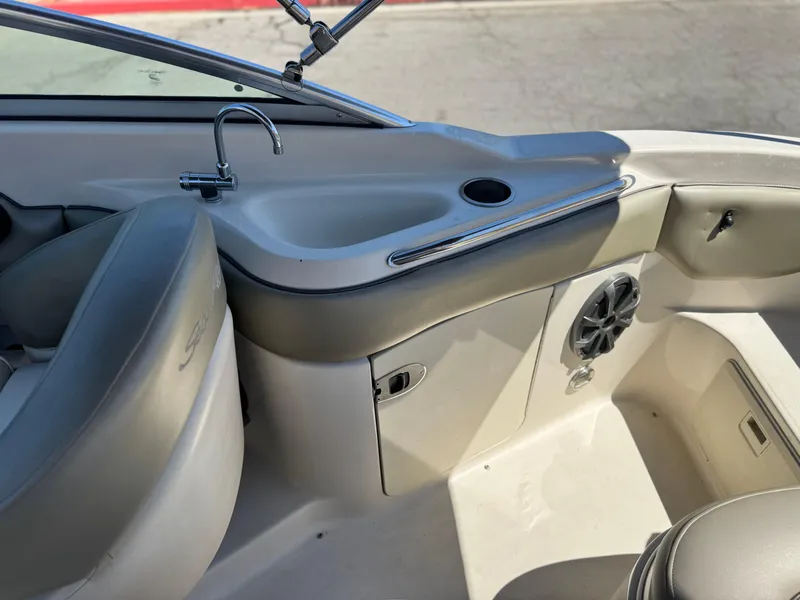 Slide: The Image of 2005 Sea Ray 220 Sundeck interior with seating, speaker, and faucet. - 19
