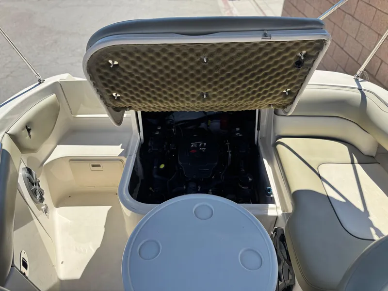 Slide: The Image of 2005 Sea Ray 220 Sundeck interior with open engine compartment, showcasing seating and storage. - 21