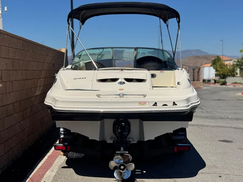 Slide: The Image of 2005 Sea Ray 220 Sundeck boat with canopy, parked on a sunny day. - 4