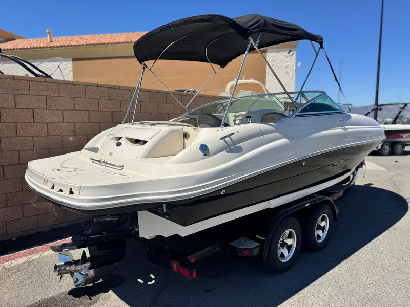 Slide: The Image of 2005 Sea Ray 220 Sundeck boat on trailer, black canopy, parked outdoors. - 5