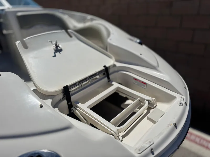 Slide: The Image of 2005 Sea Ray 220 Sundeck boat with open storage compartment and ladder. - 9