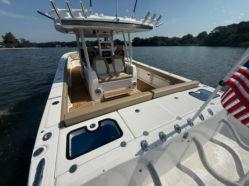 Slide: The Image of 2023 Everglades 395 Center Console boat on water, featuring spacious deck and seating. - 10