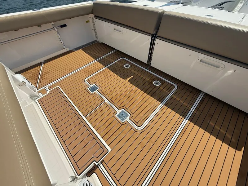 Slide: The Image of 2023 Everglades 395 Center Console boat deck with teak flooring and cushioned seating. - 13