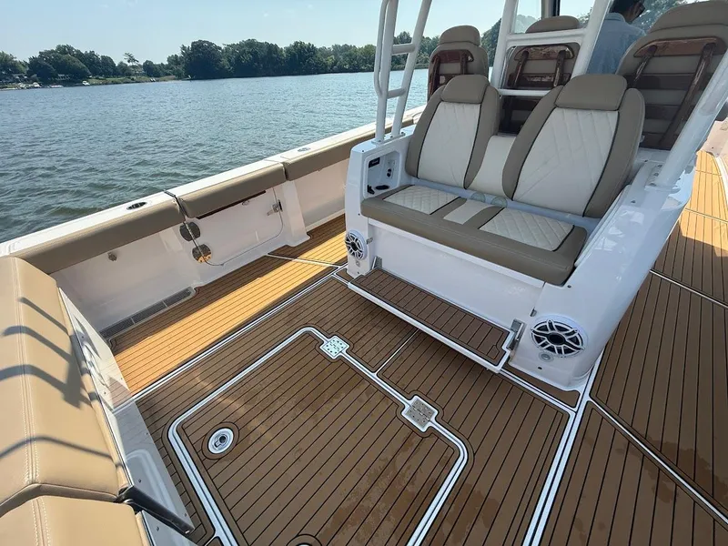 Slide: The Image of 2023 Everglades 395 Center Console boat interior with tan seating and wood flooring. - 16