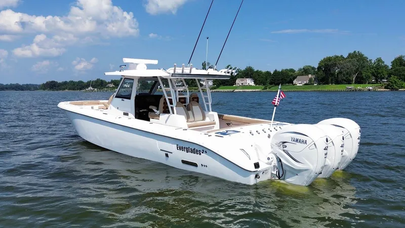 Slide: The Image of 2023 Everglades 395 Center Console boat on water, featuring triple Yamaha engines. - 2