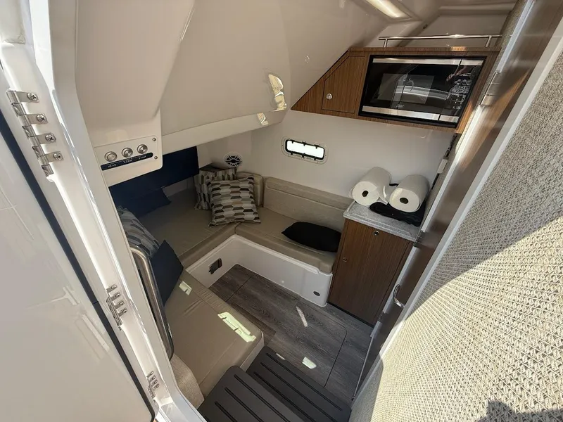 Slide: The Image of 2023 Everglades 395 Center Console cabin interior with seating, microwave, and storage. - 22