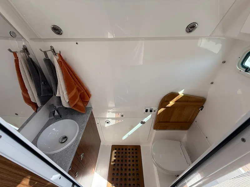Slide: The Image of 2023 Everglades 395 Center Console bathroom with sink, towels, and toilet. - 25
