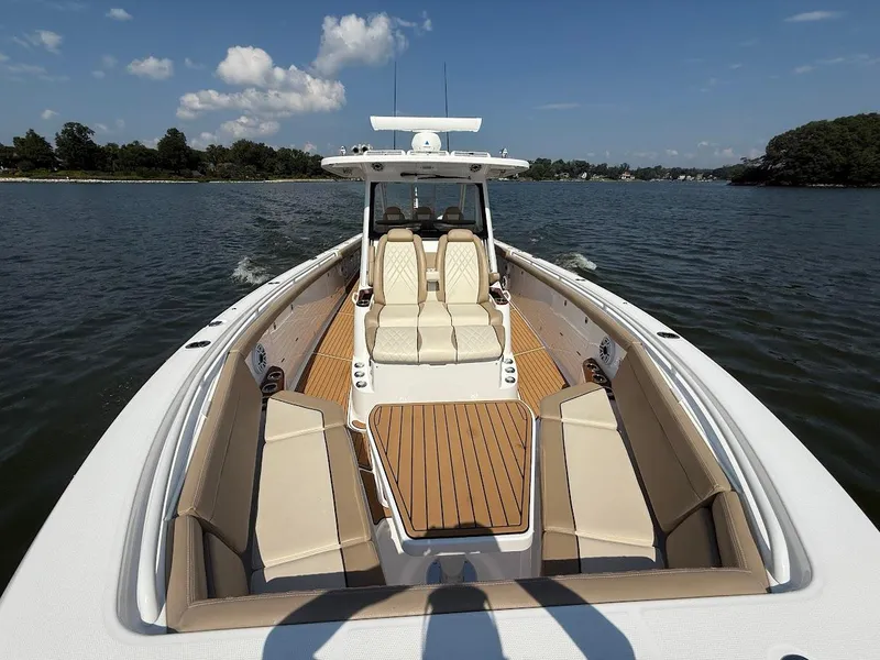 Slide: The Image of 2023 Everglades 395 Center Console boat on water, featuring spacious seating and sleek design. - 33