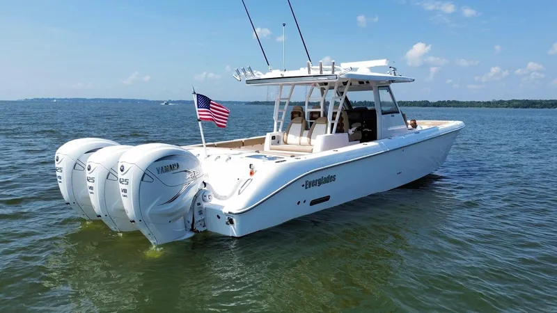 Slide: The Image of 2023 Everglades 395 Center Console boat with triple Yamaha engines on open water. - 4